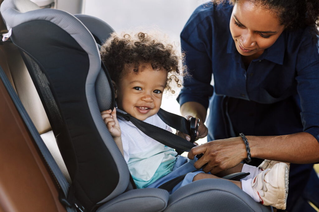 parent putting child in car seat