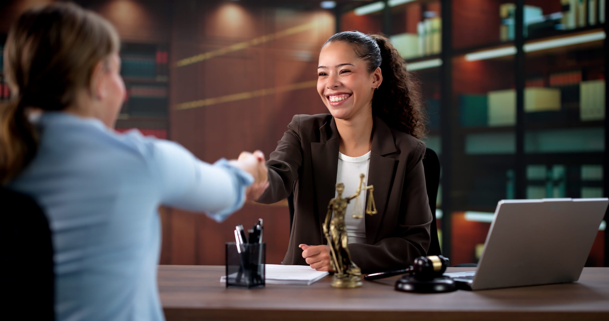 female attorney shaking hands with female client